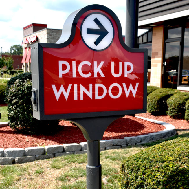 A parking directional sign that directs traffic flow in a parking lot